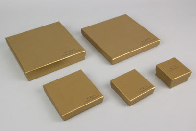 Κουτί κοσμημάτων σε χρυσό χρώμα με τυπωμένο στο καπάκι το λογότυπο της σχεδιάστριας Κατερίνας Μακρυγιάννη.
