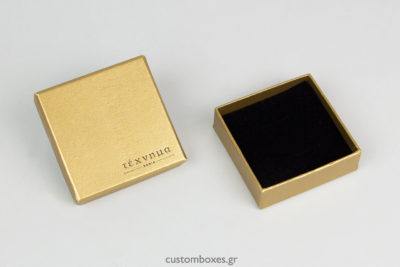 Κουτιά κοσμημάτων σε χρυσό χρώμα με τυπωμένο στο καπάκι το λογότυπο του καταστήματος «Τέχνημα» με έδρα τα Χανιά.